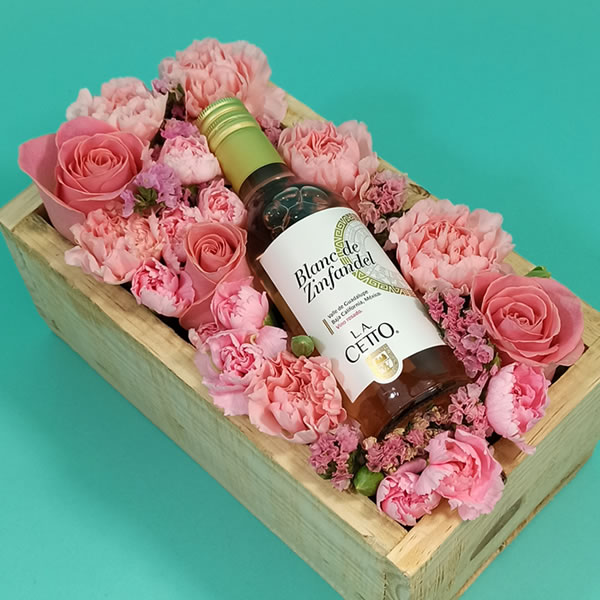 Arreglo con botella de vino y flores de tono rosa 3150